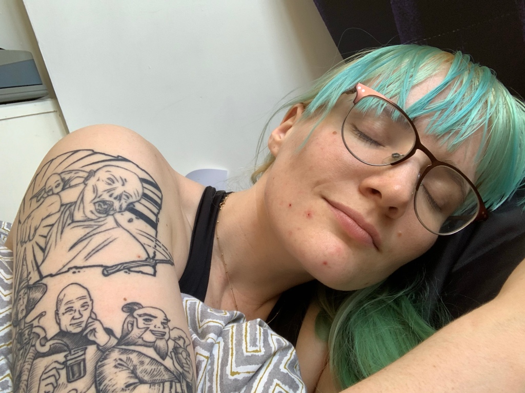 Photo of me with my tattoo. It features Saitama punching Volvemort in the face, as well as Granny, Picard and Uncle Iroh drinking tea.